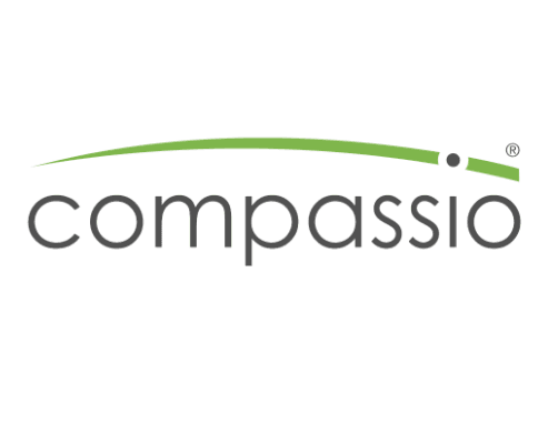 The image shows the word compassio in lowercase, gray letters, with a curved green line and two green dots arching above the last letters, forming a stylized logo that subtly hints at ev charging innovation.