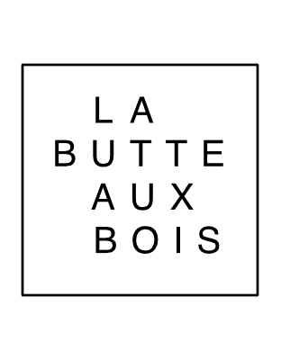 A person sits on the floor with their head down and arms wrapped around their knees, appearing sad or distressed. The plain background echoes the loneliness some feel while waiting for EV free loading stations to become available.